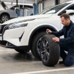 Pessoa verificando pneu de carro para rodar com mais segurança